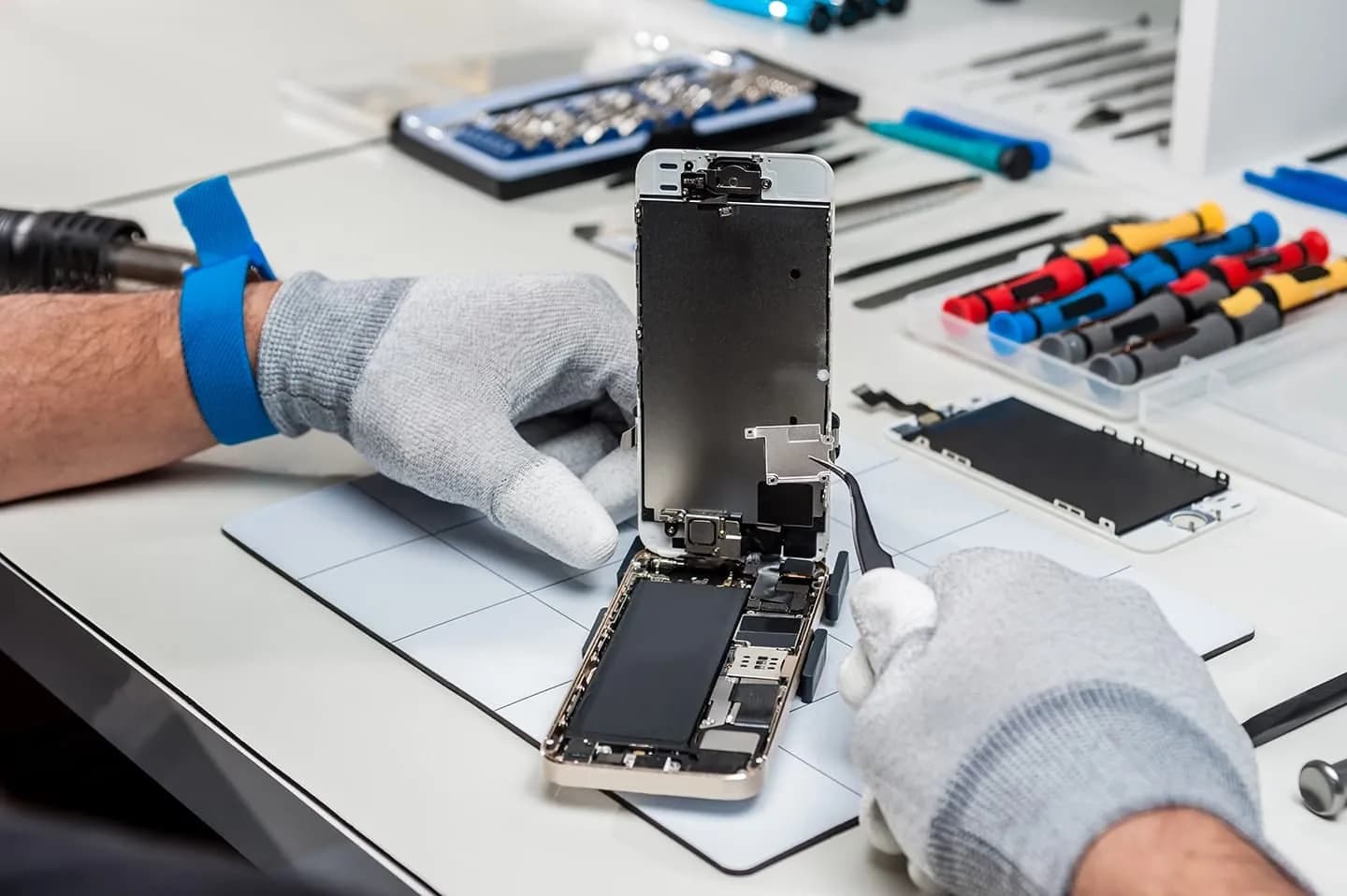 Technician repairing an iPhone at the ASM Wireless bench